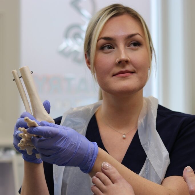 Megan at LR Podiatry, Sheffield with a model of the skeleton of a foot