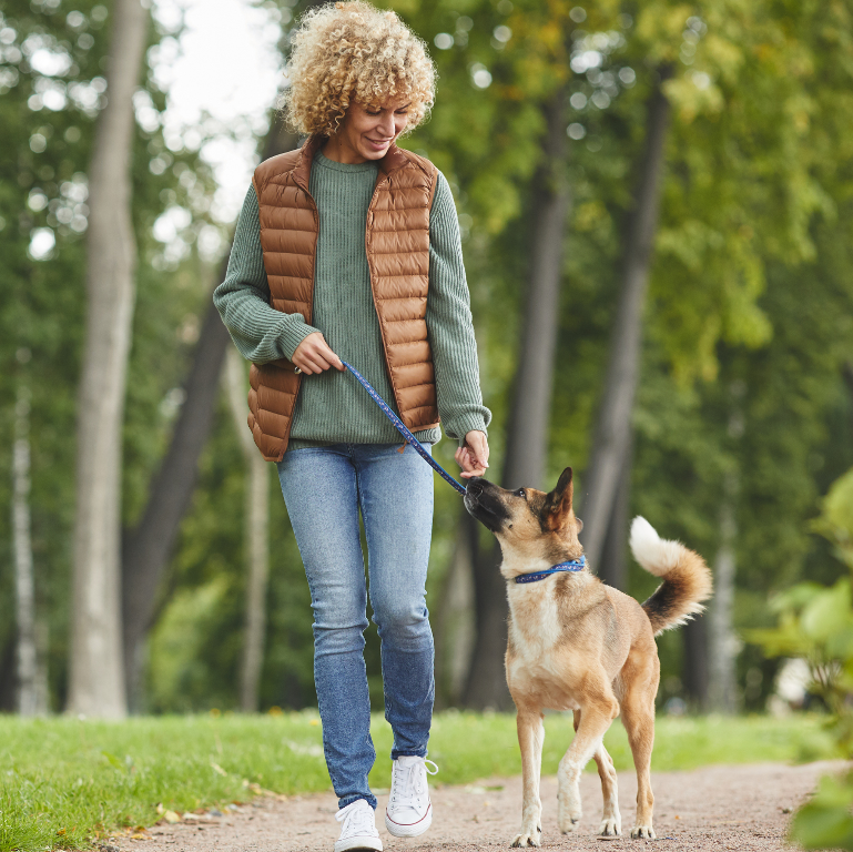 Woman walking a dog in a park